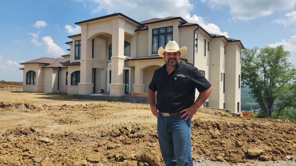 Daron, owner of Farmer Contracting, standing infront of home.